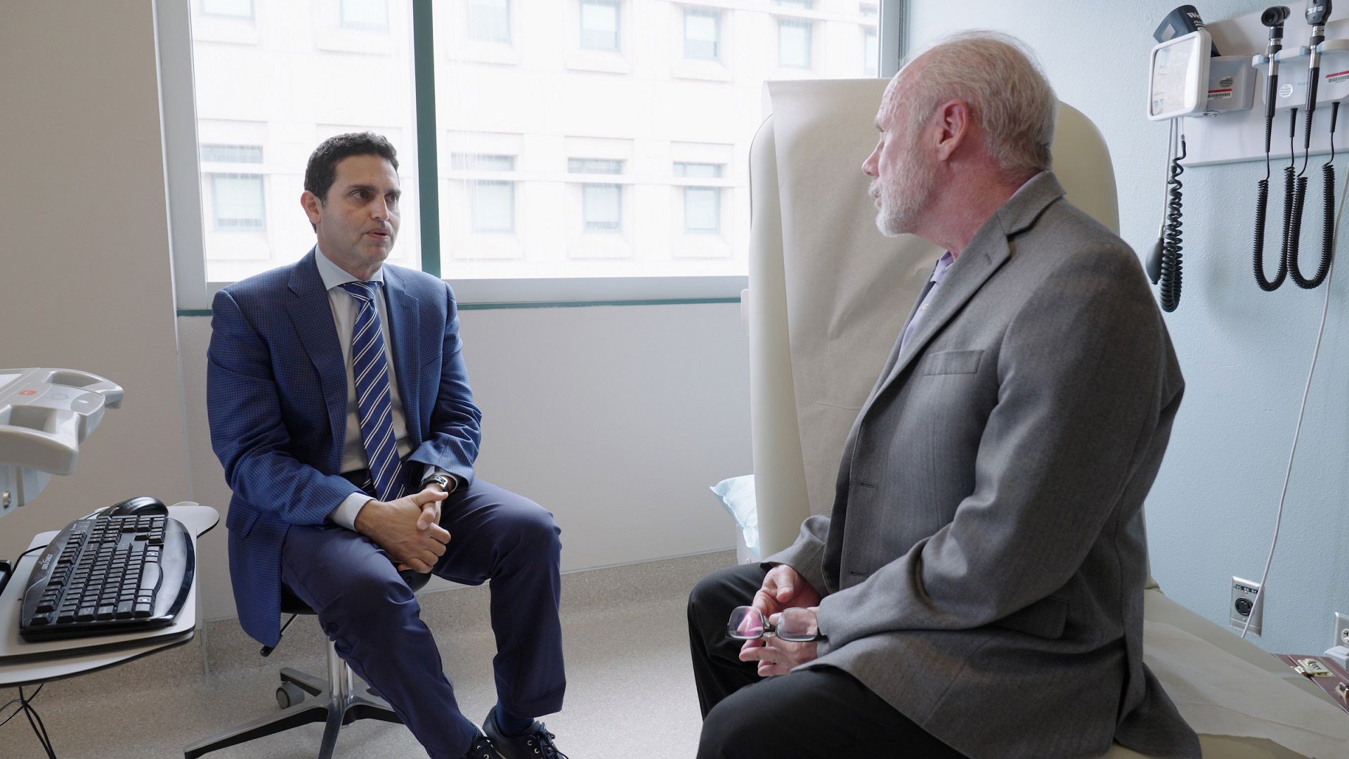 Dr. Alexander Khalessi, left, talks with endocrinologist and patient John Carr 